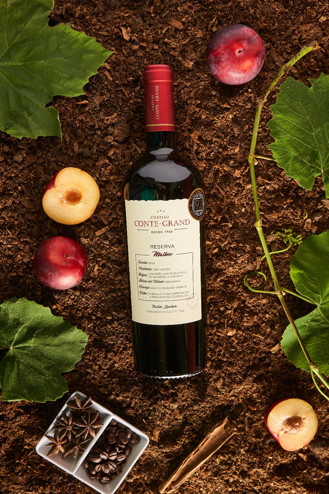 Botella principal de la selección del mes sobre tierra, hojas y frutos